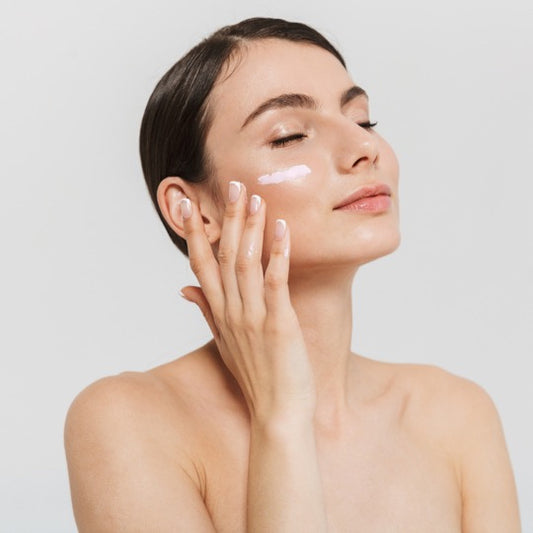 Female posing with face mask swatch on cheek