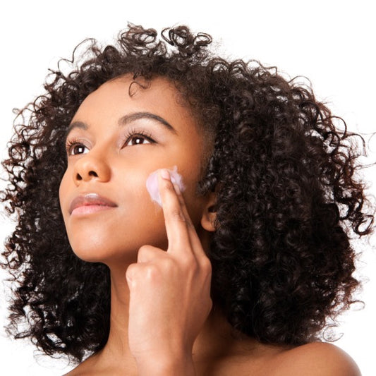 Female posing with face mask swatch on cheek - fingers applying face mask