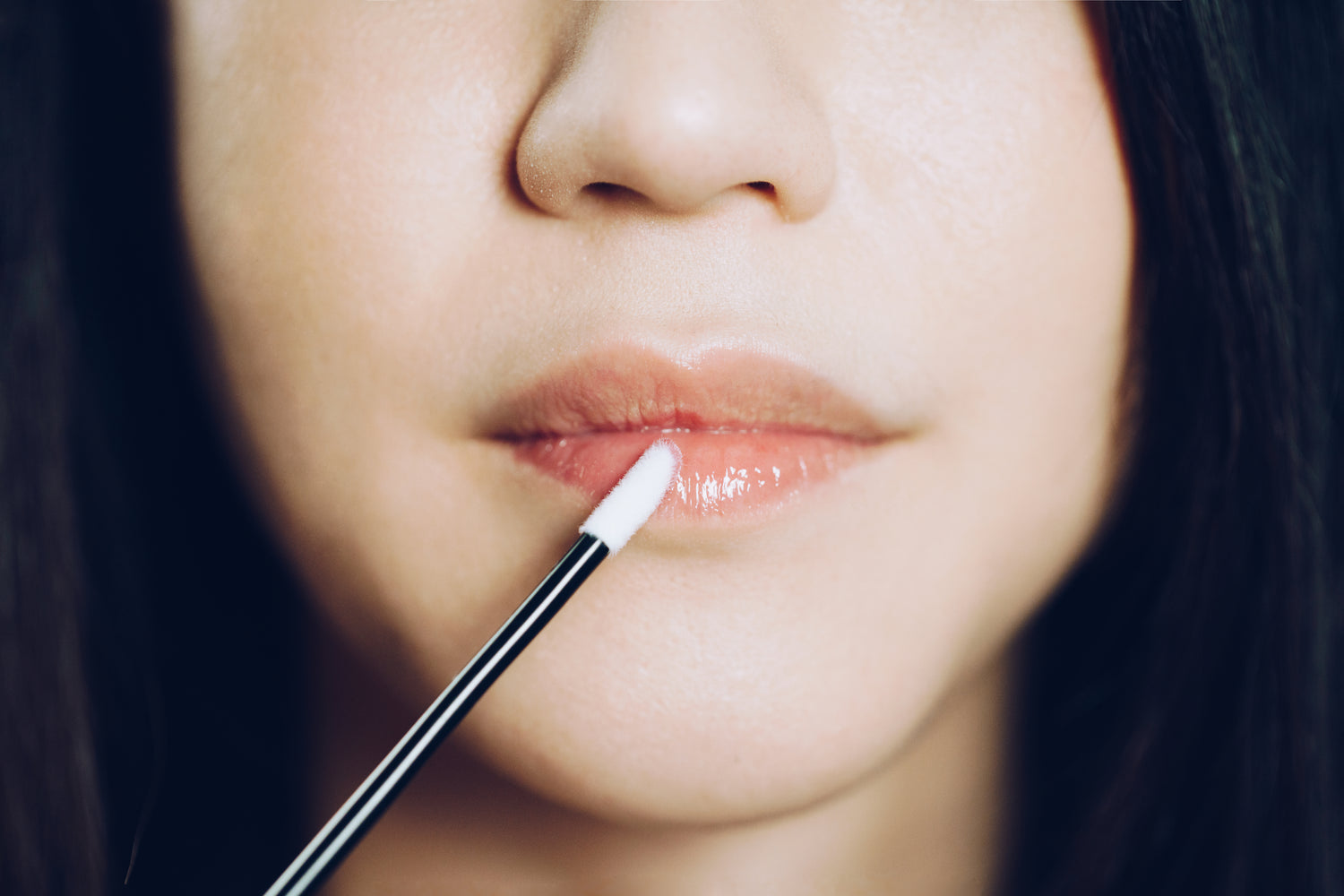 A women applying lip skin product from yuglo