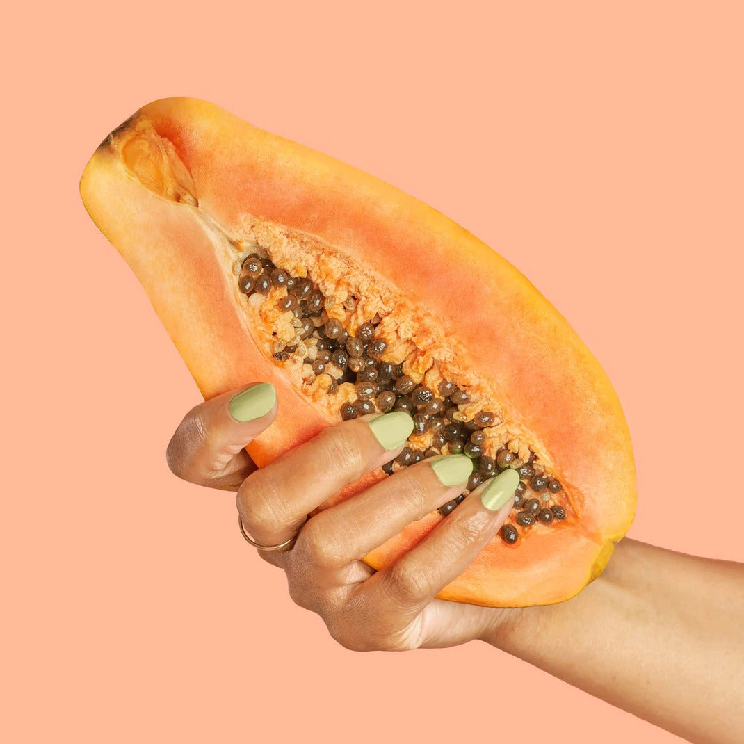 A woment holding a sliced papaya