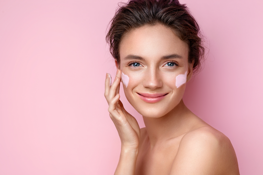 Female with face mask swatch on both cheeks - posing with hand applying the mask